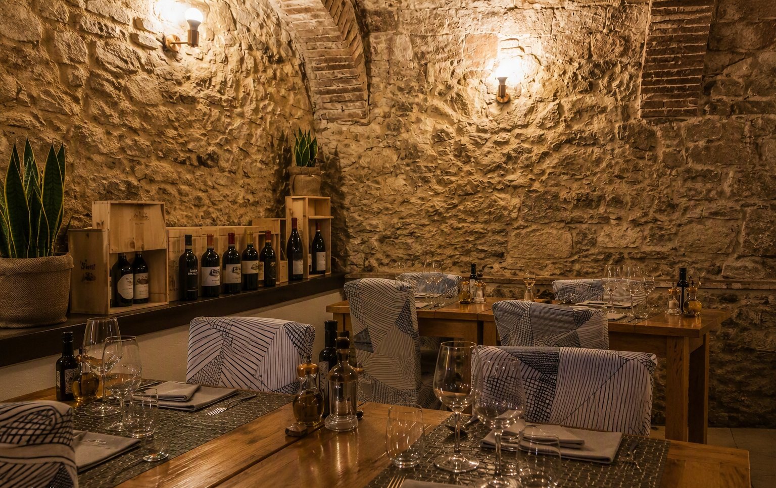 La sala in pietra con la volta e gli scaffali dei vini